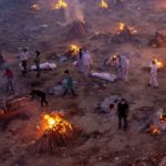 People wait to cremate COVID-19 victims at a crematorium ground in New Delhi