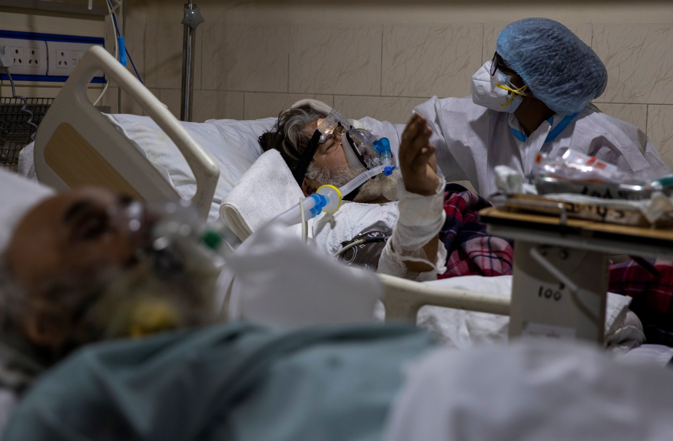 A medical worker tends to a patient suffering from COVID-19, inside the ICU ward at Holy Family Hospital in New Delhi