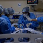 Medical workers tend to a patient suffering from COVID-19, inside the ICU ward at Holy Family Hospital in New Delhi
