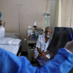A doctor checks an X-ray of a patient suffering from the coronavirus disease (COVID-19) inside a COVID-19 ward of a hospital in New Delhi