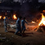People carry a body of a man, who died from the coronavirus disease (COVID-19), during his cremation at a crematorium in New Delhi