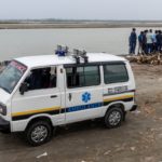 Relatives gather around the body of a man who died from the coronavirus disease (COVID-19), before cremating him on the banks of the river Ganges at Garhmukteshwar