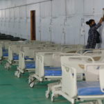 Worker cleans wall at temporary COVID-19 care facility in New Delhi