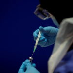 FILE PHOTO: A phial of the Pfizer/BioNTech COVID-19 vaccine concentrate is diluted with 1.8ml sodium chloride ready for use at Guy's Hospital in London