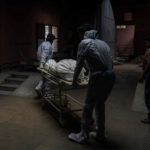 Health workers carry the body of a person, who died from complications related to the coronavirus disease (COVID-19), for cremation at a crematorium in New Delhi