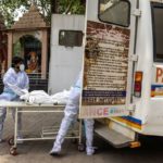 Health workers carry the body of a person, who died from complications related to the coronavirus disease (COVID-19), for cremation at a crematorium in New Delhi