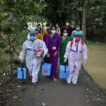 Healthcare workers carry COVISHIELD vaccine to inoculate villagers during a door-to-door vaccination and testing drive at Uttar Batora Island