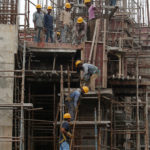Workers erect scaffolding at a construction site of a metro rail station in Kolkata