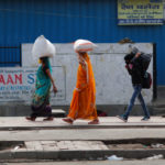 People carrying their luggage walk towards a bus station to return to their cities and villages during lockdown by the authorities to limit the spreading of coronavirus disease (COVID-19), in New Delhi