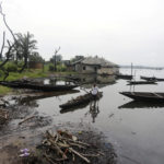 A man removes pieces of wood from a canoe in Ogoniland, Rivers State