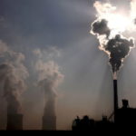 FILE PHOTO: A coal-burning power plant can be seen behind a factory in China's Inner Mongolia Autonomous Region