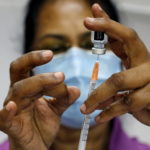 FILE PHOTO: A medical worker prepares a syringe at a coronavirus disease (COVID-19) vaccination center in Singapore