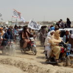 People on vehicles gather near Friendship Gate crossing on Pakistan-Afghanistan border, in Chaman
