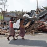 Residents carry tin sheets salvaged from the rubble of a damaged house in the aftermath of Cyclone Amphan, in South 24 Parganas district