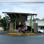 FILE PHOTO: A man rides his bicycle past a gas station that was damaged by Hurricane Maria two years ago, as Tropical Storm Karen approaches in Loiza