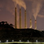 FILE PHOTO: Smoke and steam billows from the coal-fired power plant owned by Indonesia Power, next to an area for Java 9 and 10 Coal-Fired Steam Power Plant Project in Suralaya