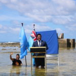 Tuvalu's Minister for Justice, Communication & Foreign Affairs Simon Kofe gives a COP26 statement while standing in the ocean in Funafuti