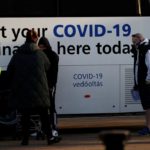 People wait to get COVID-19 booster vaccine at mobile vaccination centre in Bolton