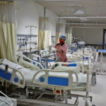 Staff member cleans medical equipment inside ward set up for Omicron coronavirus variant infected people at the Civil Hospital in Ahmedabad