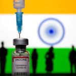 FILE PHOTO: 3D-printed small toy figurines, a syringe and vial labelled "coronavirus disease (COVID-19) vaccine" are seen in front of India flag in this illustration