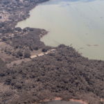 A general view from a New Zealand Defence Force P-3K2 Orion surveillance flight shows ash covered homes and vegetation over Nomuka in Tonga