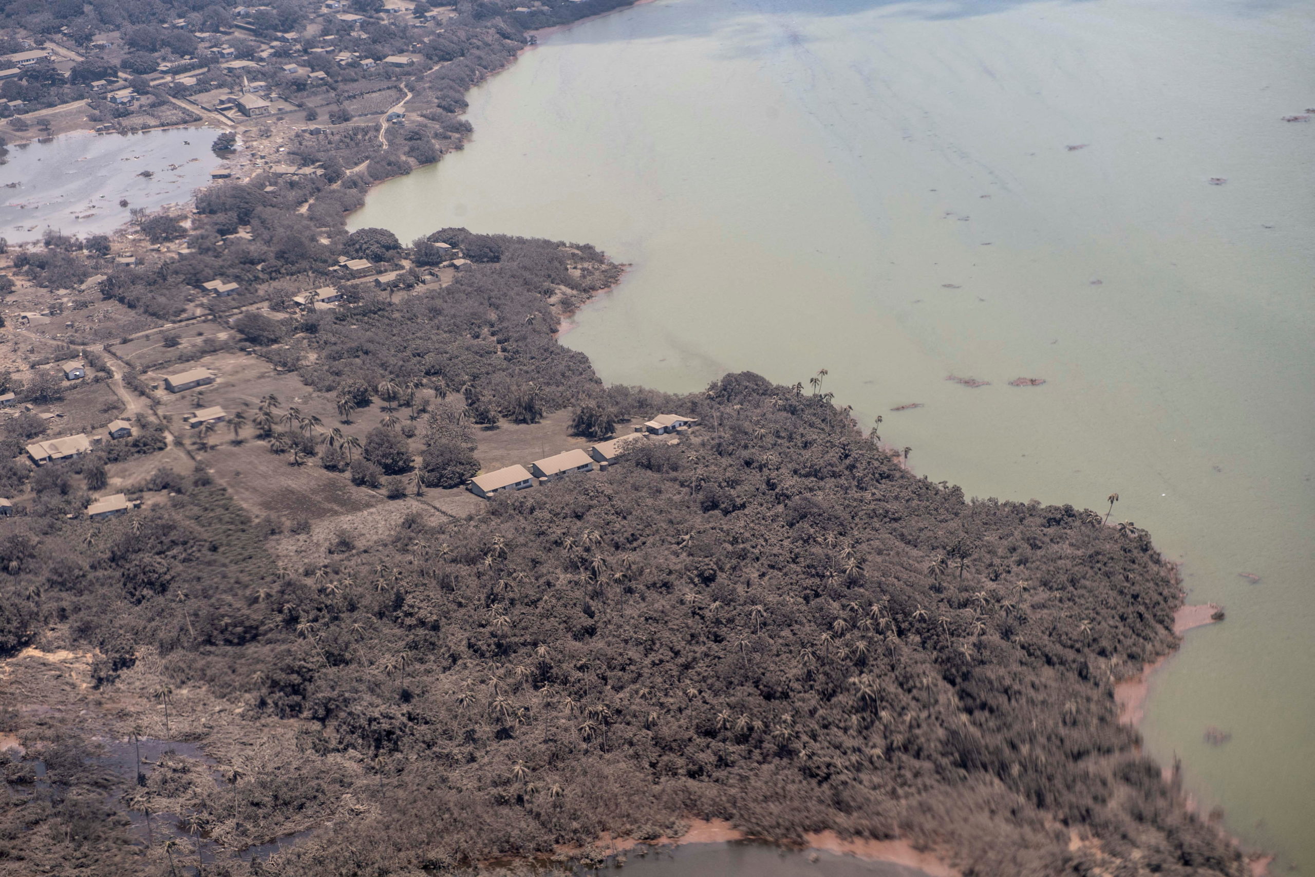 A general view from a New Zealand Defence Force P-3K2 Orion surveillance flight shows ash covered homes and vegetation over Nomuka in Tonga
