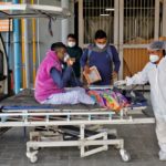 A man with breathing problem is wheeled inside a COVID-19 hospital for treatment in Ahmedabad