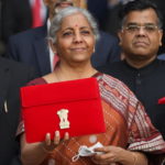 India's Finance Minister Nirmala Sitharaman holds up a folder with the Government of India’s logo