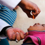 Boy receives polio vaccination drops during a house-to-house vaccination campaign in Sanaa