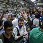 Commuters travel in a packed train in Mumbai