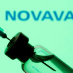 FILE PHOTO: FILE PHOTO: FILE PHOTO: Vial and sryinge are seen in front of displayed Novavax logo in this illustration