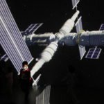 FILE PHOTO: A child stands near a screen showing the image of the Tianhe space station