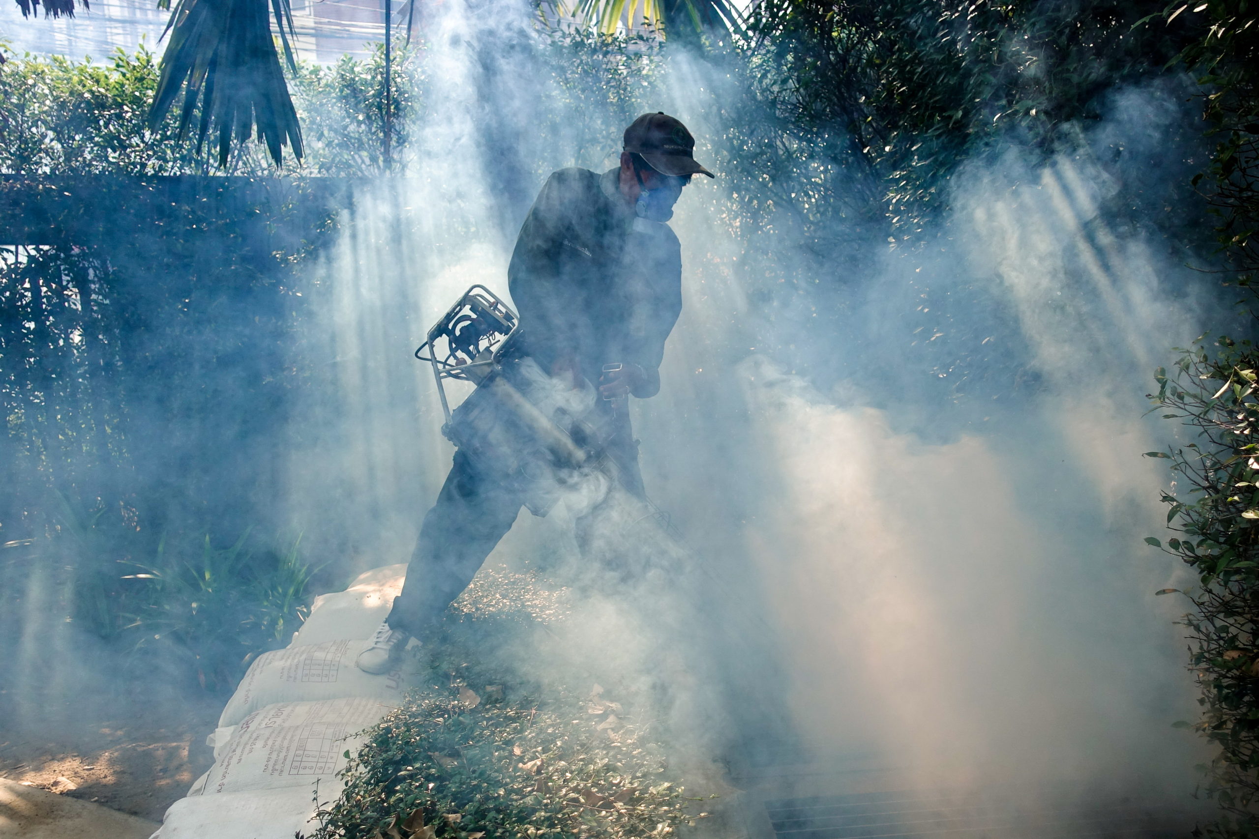 FILE PHOTO: A worker sprays insecticide for mosquitos at a village in Bangkok