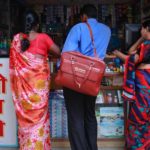 A medical representative with Abbott talks to a chemist at a market in Pune