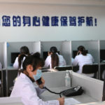 FILE PHOTO: Hotline operator for a free counselling service answers a phone while wearing a face mask, as the country is hit by an outbreak of the novel coronavirus, in Shenyang