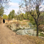 A veiled woman walks on a road damaged by flooding exacerbated by glacial melt, in Kashmir's Chendargund village, India, October 12, 2022. Thomson Reuters Foundation/Athar Parvaiz